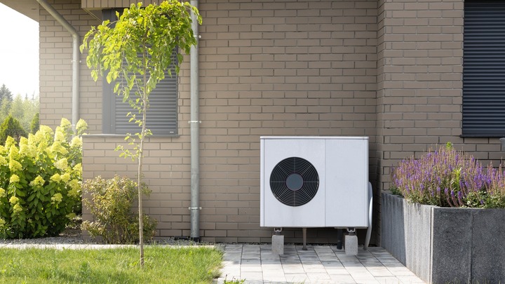 Bild zeigt eine Wärmepumpe an einer Hauswand verlinkt auf Blogbeitrag Wärmepumpen: Effizientes Heizen auch effizient versichern!